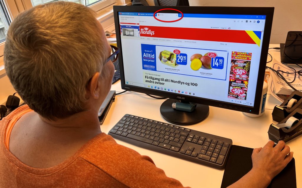 En person sitter foran PC og ser på en nettside