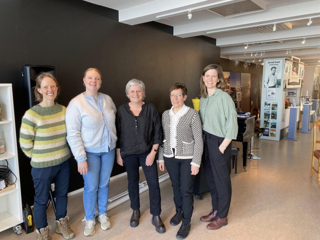 fem mennesker ser i kamera og smiler