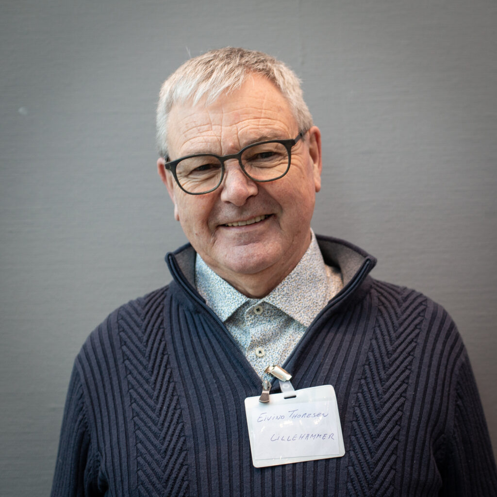 Mann med briller ser i kamera og smiler